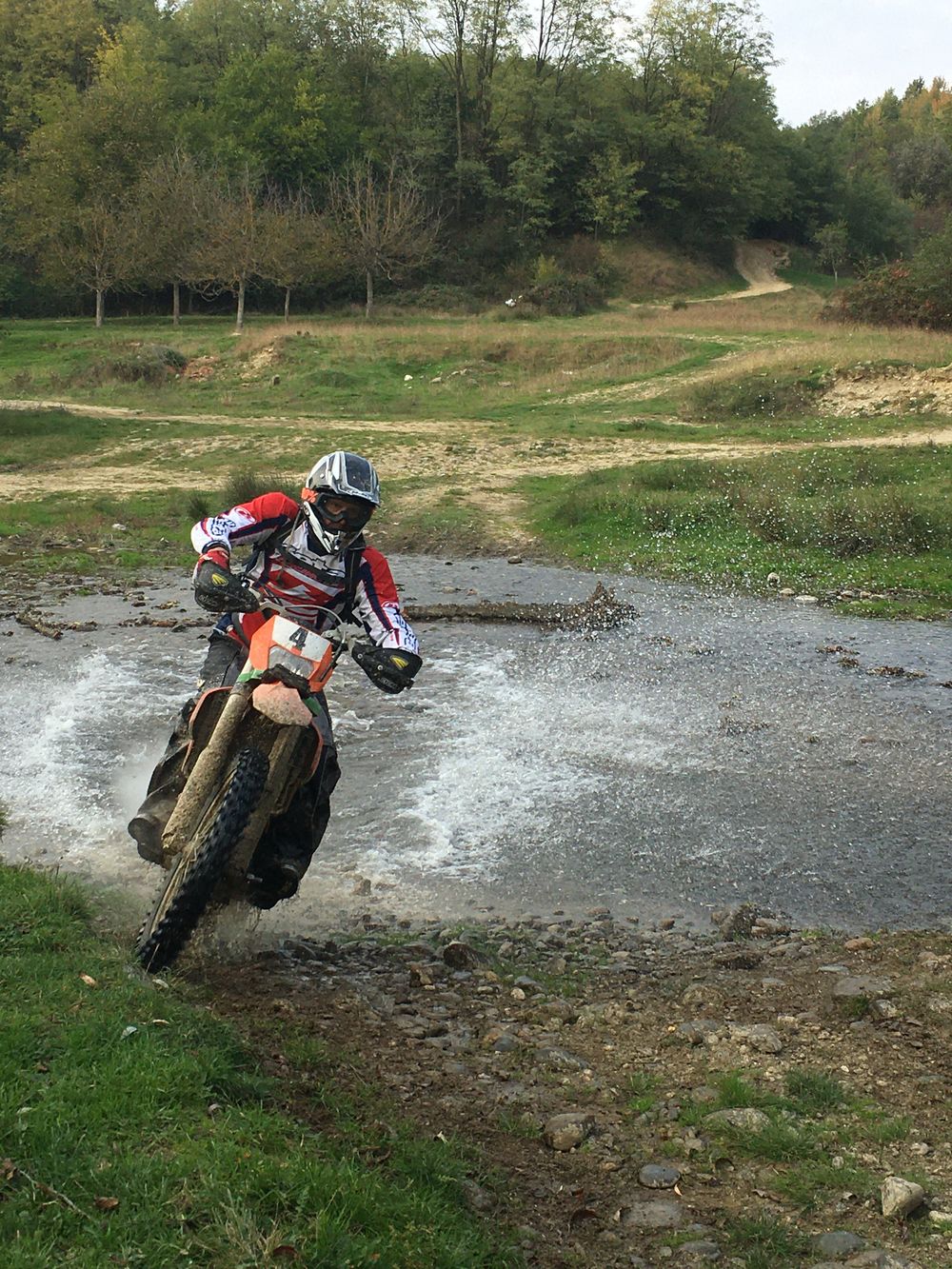 Endurofahrer durchquert mit Tempo ein Flussbett